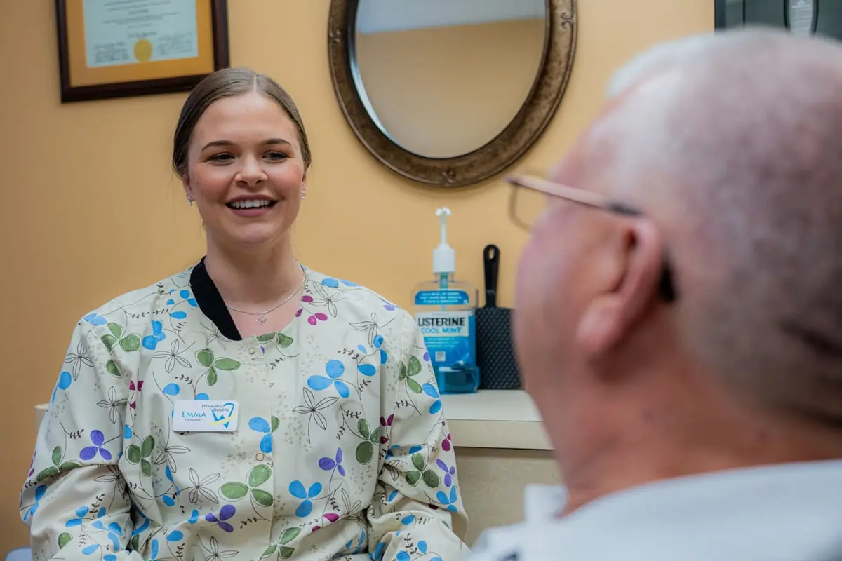 Dental assistant educating a patient about gum disease